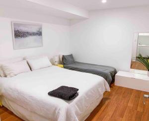 een slaapkamer met een groot wit bed en een spiegel bij Modern house close to CBD & Adelaide Oval in Prospect