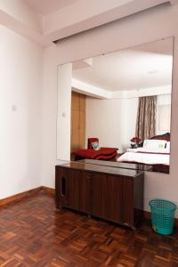 a bedroom with a large mirror above a bed at spacious & stylish 4bdr kileleshwa in Nairobi