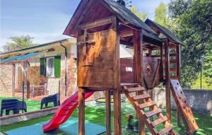 uma casa de jogos de madeira com um escorrega num quintal em Il Molino B em Rosignano Marittimo