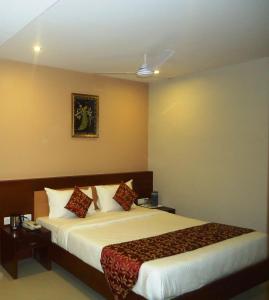 a bedroom with a bed and a painting on the wall at Pleasant Inn in Pondicherry