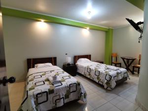 a bedroom with two beds and a table and chairs at Hostal "Vista del Valle" in La Merced