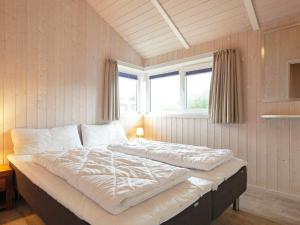 ein großes Bett in einem Zimmer mit Fenster in der Unterkunft Three-Bedroom Holiday home in Grömitz 5 in Grömitz