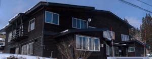 um edifício preto com janelas do lado em Hai Lodge em Otari