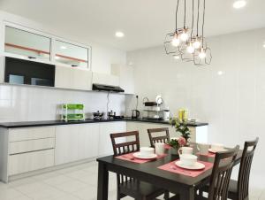 a kitchen with a table and chairs in a kitchen at Urban ONE Homestay 8pax 3Rooms in Kuching