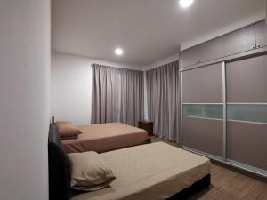 a hotel room with two beds and a closet at Urban ONE Homestay 8pax 3Rooms in Kuching