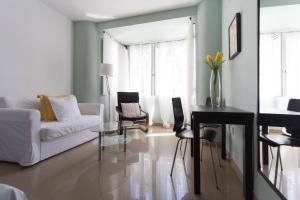 a living room filled with furniture and a window at Apartamentos Diaber Edificio Constitución in Seville