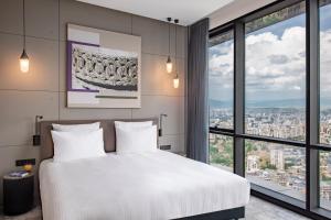 A bed or beds in a room at Pullman Tbilisi Axis Towers