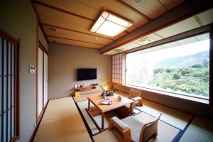 una sala da pranzo con tavolo e una grande finestra di Radium Kagaya Taipei a Taipei