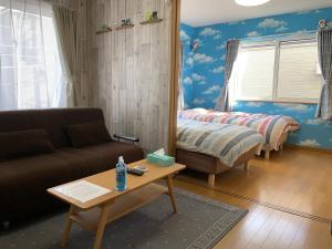 a living room with a couch and a bed at Creative　apartment in Kita-sanjō