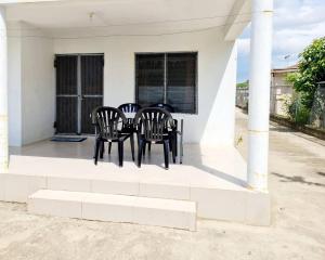 - une table et des chaises assises sur la terrasse couverte d'une maison dans l'établissement Masters 2 Bedroom Apartment Westfield, à Nadi
