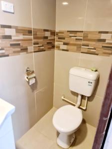 uma casa de banho com um WC branco num quarto em Masters 2 Bedroom Apartment Westfield em Nadi