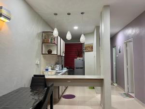 a kitchen with a long counter in a room at Batu Feringgi Homestay in Batu Ferringhi