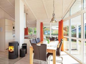 ein Esszimmer mit einem Tisch, Stühlen und einem Kamin in der Unterkunft Three-Bedroom Holiday home in Grömitz 13 in Grömitz