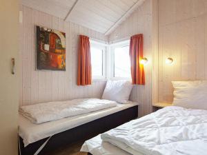 two beds in a room with a window and two bedsitures at Three-Bedroom Holiday home in Grömitz 13 in Grömitz