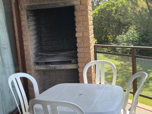 a white table and chairs on a porch with a fireplace at Margate Uvongo Seeskulp in Margate