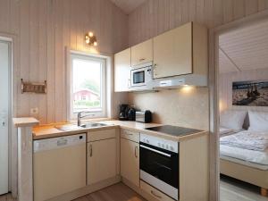cocina pequeña con fregadero y cama en Three-Bedroom Holiday home in Grömitz 20, en Grömitz