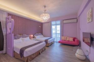 ein lila Zimmer mit 2 Betten und einem Sofa in der Unterkunft 桔子圓包棟民宿 小團體包棟 tesla 充電 in Taitung