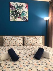a bedroom with a bed with pillows and a blue wall at 2 Bedroom Deluxe Beach Apartment Al Marjan in Ras al Khaimah