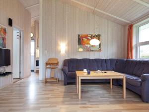 a living room with a blue couch and a table at Three-Bedroom Holiday home in Grömitz 11 in Grömitz