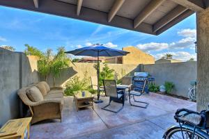 un patio con una mesa y una sombrilla en Tempe Oasis 2 Mi to Sloan Park, Walk to ASU Campus, en Tempe