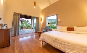 een slaapkamer met een bed en een groot raam bij Touchwood Bliss Igatpuri in Nashik