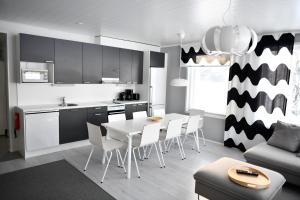 uma cozinha e sala de estar com mesa e cadeiras em Lake Residence Ukkohalla em Hyrynsalmi
