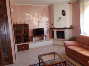 een woonkamer met een bank en een open haard bij casa papillon in Sestino