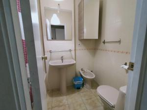 a bathroom with a sink and a toilet at CASA PORTELA APARTAMENTOS in Revolta