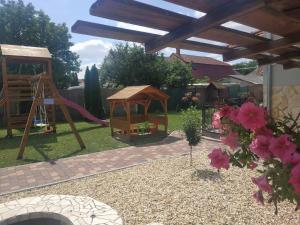 a backyard with a playground with a slide and a swing at Aranyhal apartman in Sárvár