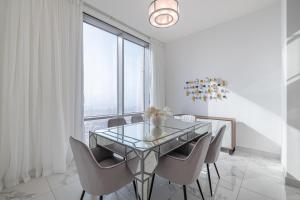 ドバイにあるSpacious 3BDR Apartment and maid room with Burj Khalifa Viewのダイニングルーム(ガラスのテーブル、椅子付)