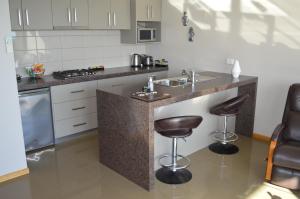 a kitchen with a sink and two bar stools at Rocky Cape Retreat in Rocky Cape