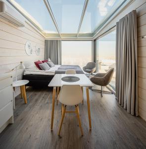 een slaapkamer met een bed en een tafel en stoelen bij Ukkohalla Sky Cabin Glass Suite in Hyrynsalmi