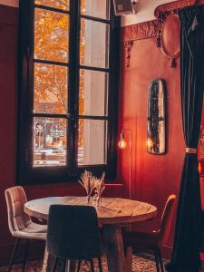 uma sala de jantar com uma mesa e uma janela em Royal Hôtel em Nîmes