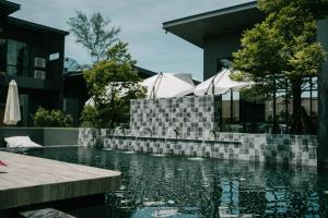a swimming pool in front of a house at INN BLOG HOTEL Pakbara in Satun