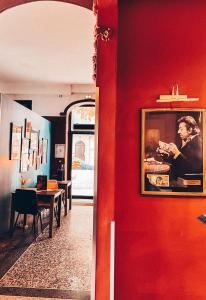 una habitación con una pared roja con una foto de un hombre en Royal Hôtel en Nimes