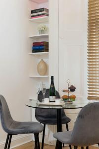 een tafel met 2 stoelen en een fles wijn bij Notting Hill Apartment in Londen