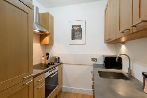 een kleine keuken met een wastafel en een fornuis bij Notting Hill Apartment in Londen