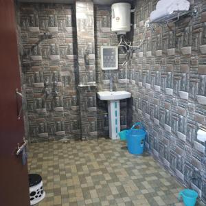 baño con lavabo y pared de piedra en Mountain view stay in Auli en Joshīmath