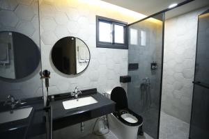 ein Badezimmer mit einem Waschbecken, einem WC und einem Spiegel in der Unterkunft Walking Island in Xiaoliuqiu