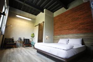 ein Schlafzimmer mit einem großen Bett und einer Ziegelwand in der Unterkunft Walking Island in Xiaoliuqiu