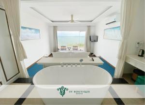 a bath tub in a room with a view of the ocean at SV Boutique Resort in Vung Tau
