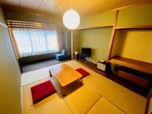 a small living room with a table and a chair at ビューリゾートインとみや in Yuzawa