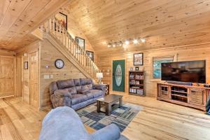 a living room with a couch and a tv at Ellijay Resort Cabin with Deck and Enclosed Porch! in Ellijay