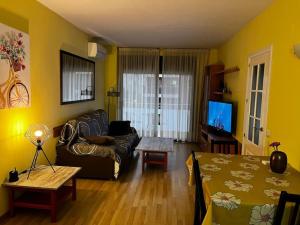 sala de estar con sofá y mesa en Hermoso apartamento con piscina a 300m de la playa, en Lloret de Mar