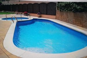 ein großer Pool mit blauem Wasser in der Unterkunft Hermoso apartamento con piscina a 300m de la playa in Lloret de Mar