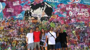 people standing next to a wall with graffiti on it at Hostel One Old Town in Prague