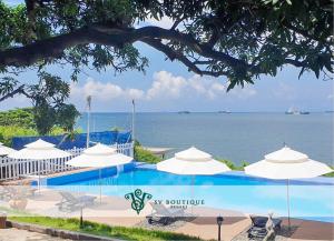 a swimming pool with white umbrellas and the ocean at SV Boutique Resort in Vung Tau +30 photos
