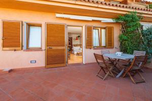 a patio with a table and chairs in front of a house at Casa Erica in Palau
