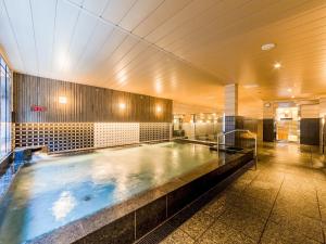 a large swimming pool in a building at APA Hotel & Resort Roppongi-Eki-Higashi in Tokyo