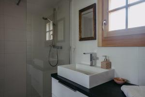ein weißes Bad mit einem Waschbecken und einer Dusche in der Unterkunft Kellerstöckl Berg 106 in Strem